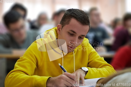 Image of student taking notes while studying in high school