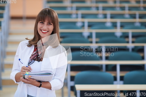 Image of famale student using pen and notebook