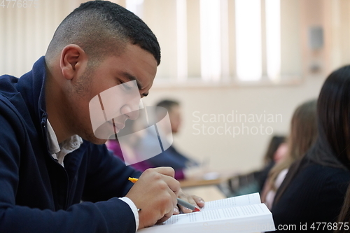 Image of student taking notes while studying in high school