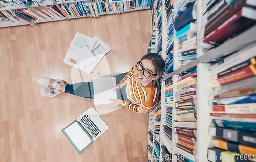 Image of the student uses a notebook and a school library