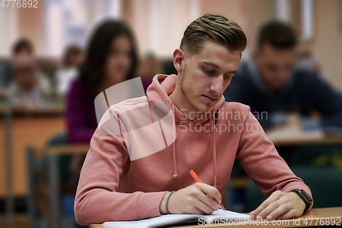 Image of student taking notes while studying in high school