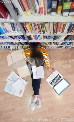 Image of the student uses a notebook and a school library