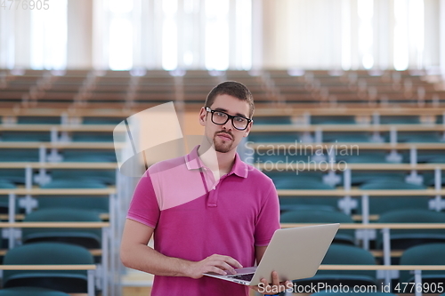 Image of Man student working on laptop in college classroom