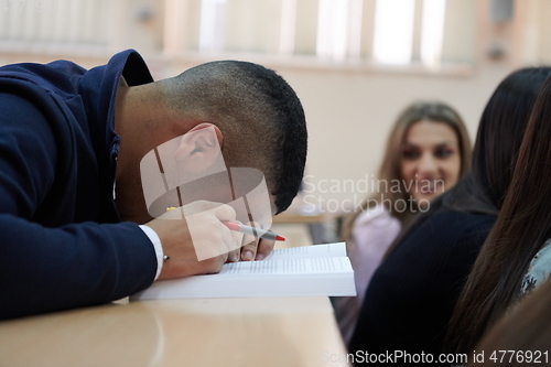 Image of student taking notes while studying in high school