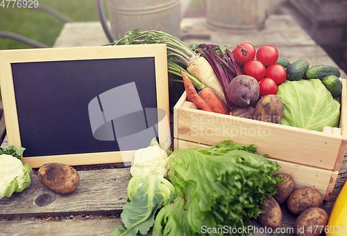 Image of close up of vegetables with chalkboard on farm