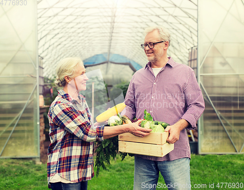 Image of senior couple with box of vegetables on farm