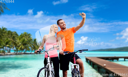 Image of couple with bicycles taking selfie by smartphone