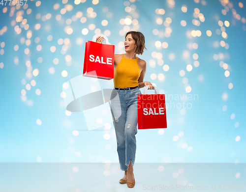 Image of happy smiling young woman with shopping bags