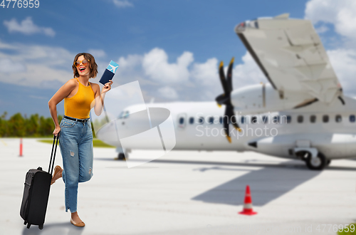 Image of woman with air ticket and travel bag on airfield