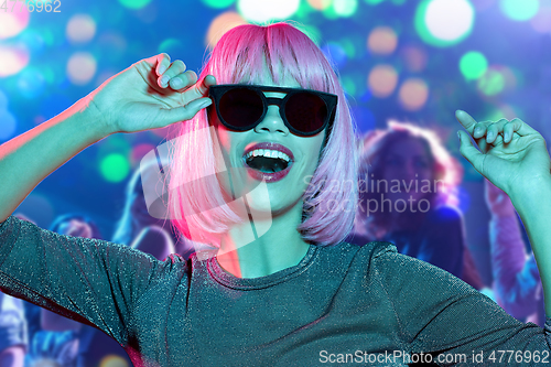 Image of woman in wig and sunglasses dancing at nightclub