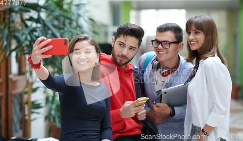 Image of Group of multiethnic teenagers taking a selfie in school