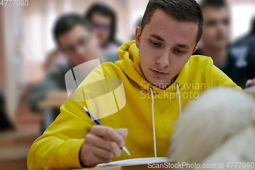 Image of student taking notes while studying in high school