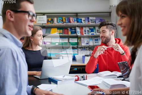 Image of students group working on school project together on tablet computer at modern university