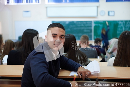 Image of student taking notes while studying in high school