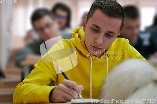 Image of student taking notes while studying in high school