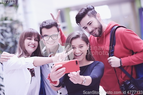 Image of Group of multiethnic teenagers taking a selfie in school