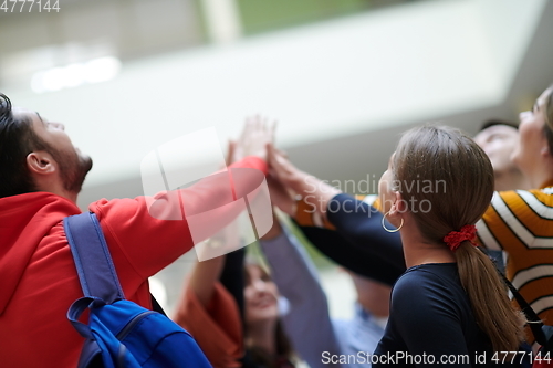 Image of students together in problem, arm in the air