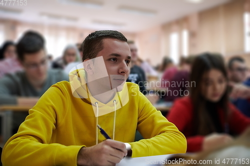 Image of student taking notes while studying in high school