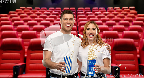 Image of happy couple in t-shirts with popcorn at cinema