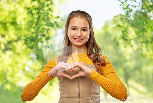 Image of smiling teenage girl making hand heart