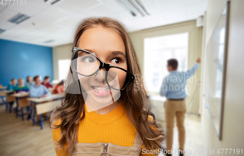 Image of smiling teenage student girl in glasses at school