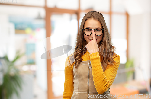 Image of smiling teenage student girl in glasses at school