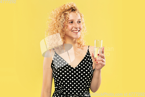 Image of Caucasian young woman\'s half-length portrait on yellow background