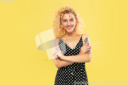 Image of Caucasian young woman\'s half-length portrait on yellow background