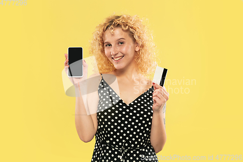 Image of Caucasian young woman\'s half-length portrait on yellow background