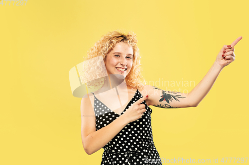 Image of Caucasian young woman\'s half-length portrait on yellow background
