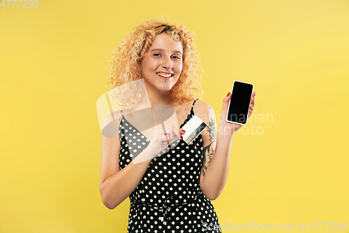Image of Caucasian young woman\'s half-length portrait on yellow background