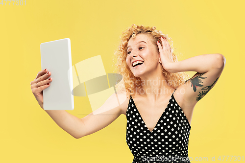 Image of Caucasian young woman\'s half-length portrait on yellow background