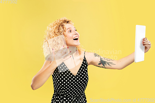 Image of Caucasian young woman\'s half-length portrait on yellow background