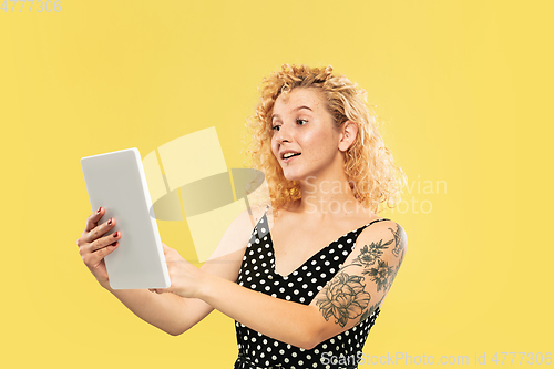 Image of Caucasian young woman\'s half-length portrait on yellow background