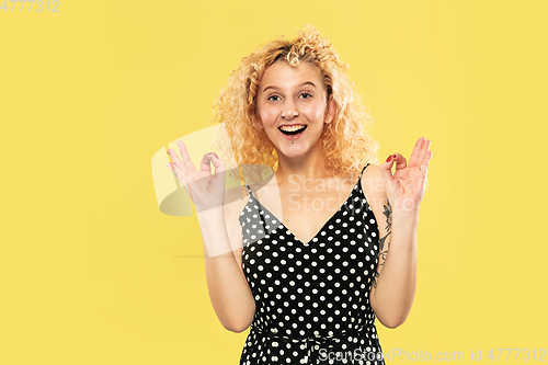 Image of Caucasian young woman\'s half-length portrait on yellow background