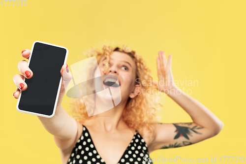 Image of Caucasian young woman\'s half-length portrait on yellow background