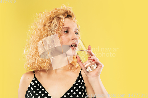 Image of Caucasian young woman\'s half-length portrait on yellow background