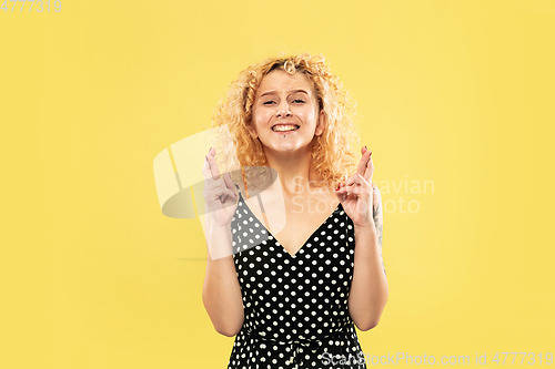 Image of Caucasian young woman\'s half-length portrait on yellow background