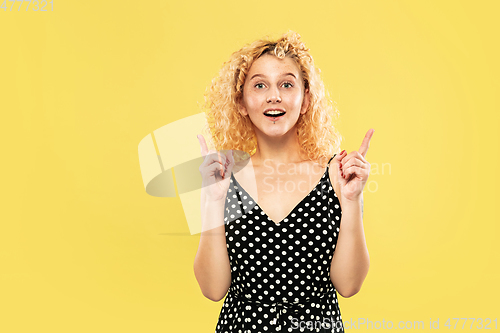 Image of Caucasian young woman\'s half-length portrait on yellow background