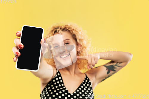 Image of Caucasian young woman\'s half-length portrait on yellow background