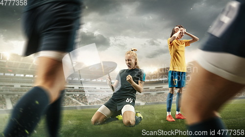 Image of Female soccer or football players kicking ball at the stadium