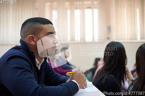 Image of student taking notes while studying in high school