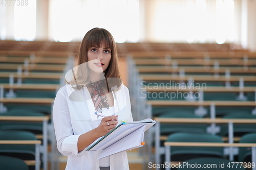 Image of famale student using pen and notebook