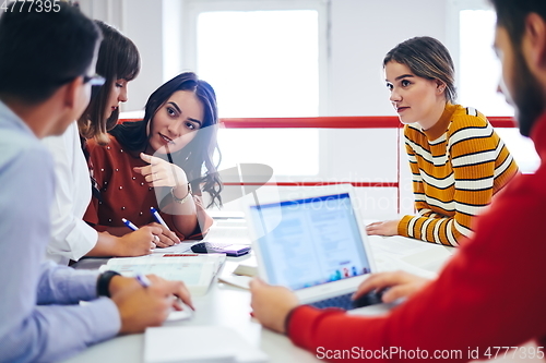 Image of students group working on school project together on tablet computer at modern university