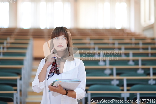 Image of famale student using pen and notebook