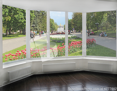 Image of window overlooking the city park where people have a rest