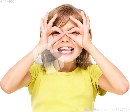 Image of Happy little girl is showing glasses gesture