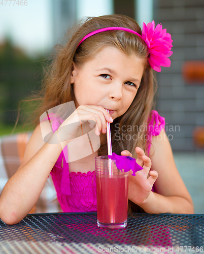 Image of Little girl is drinking cherry juice