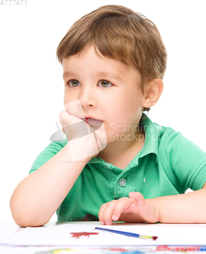 Image of Little boy is playing with paints