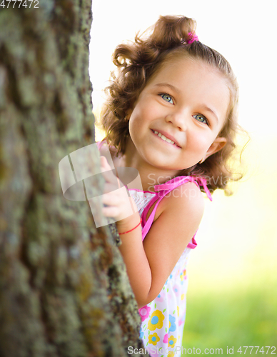 Image of Cute little girl is playing hide and seek